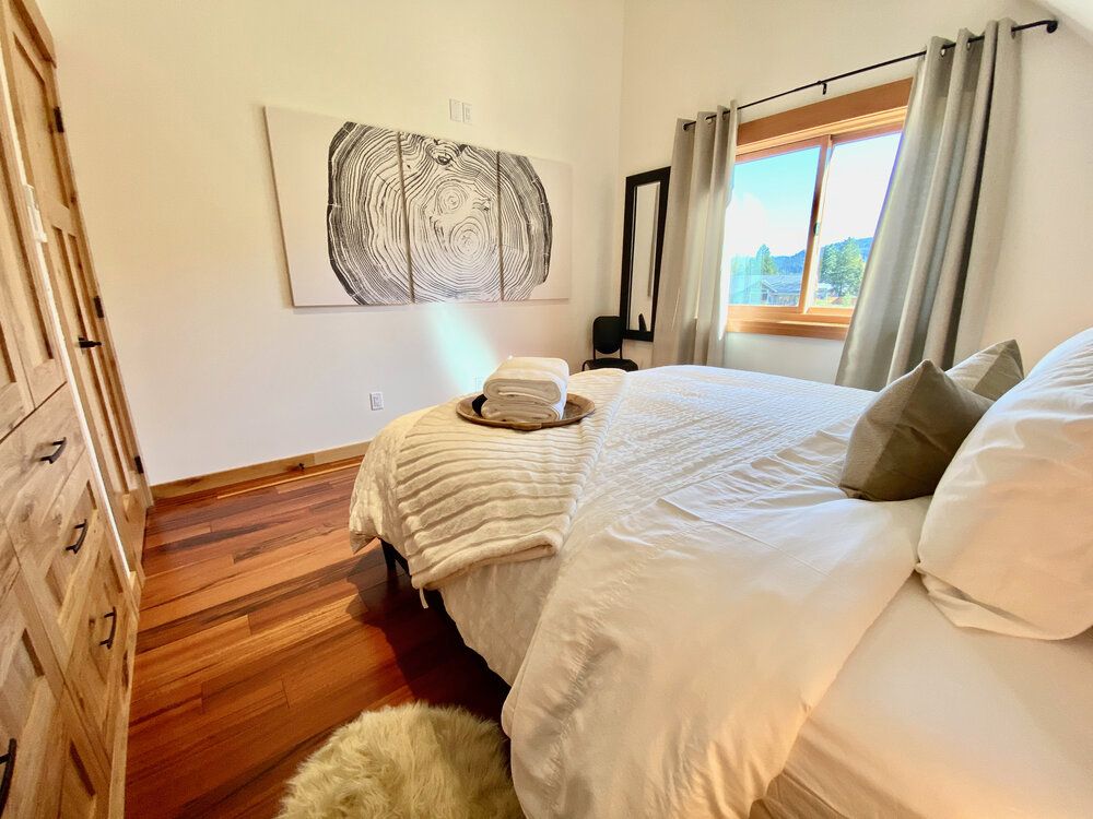 Upstairs primary bedroom with a king bed and mountain-facing window at The Cascade Chalet