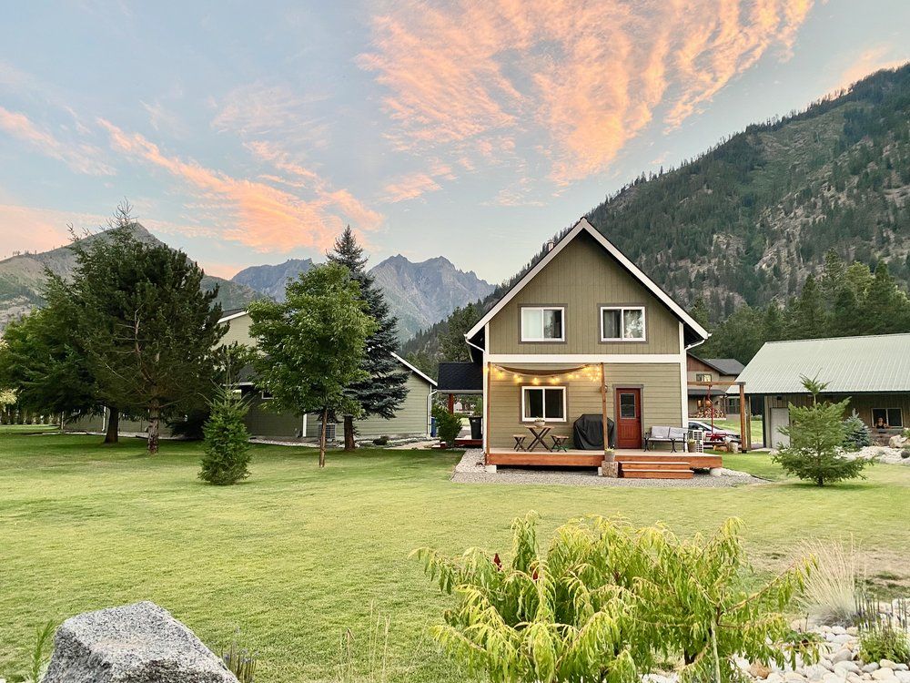 The Cascade Chalet at sunset with a large lawn and Cascade mountain views in Leavenworth WA