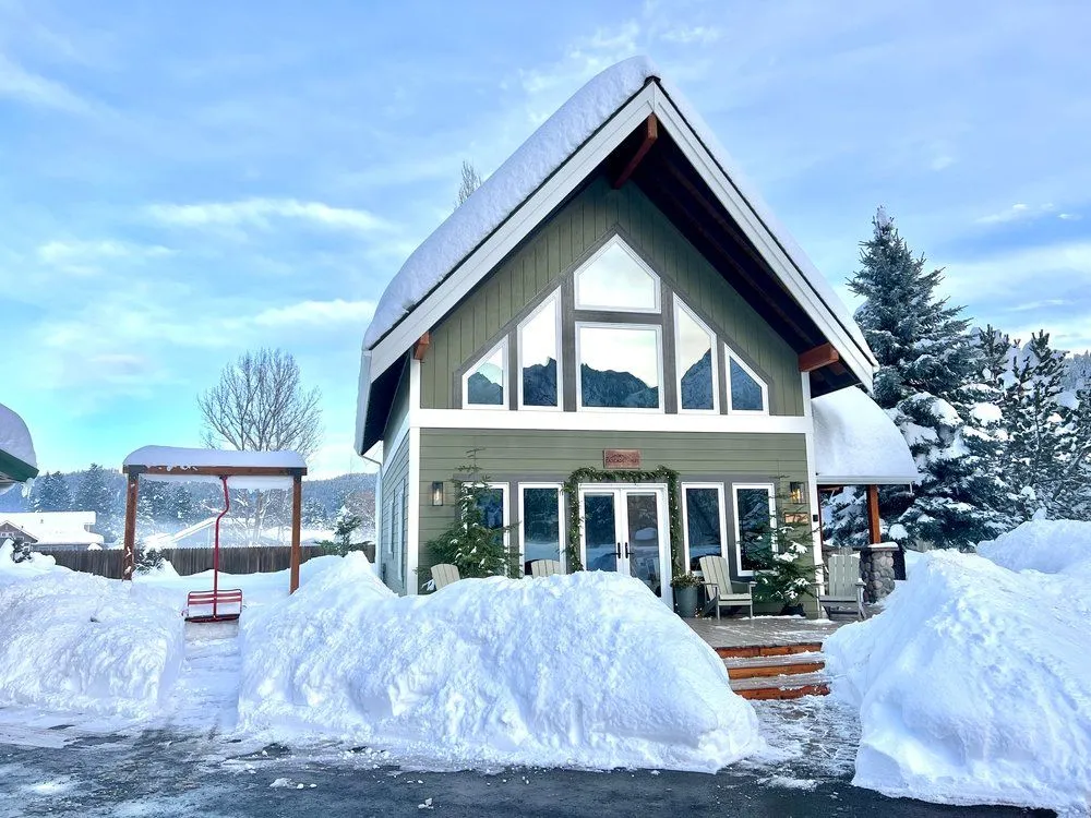 The Cascade Chalet in deep snow with its gable windows reflecting the Cascade mountains