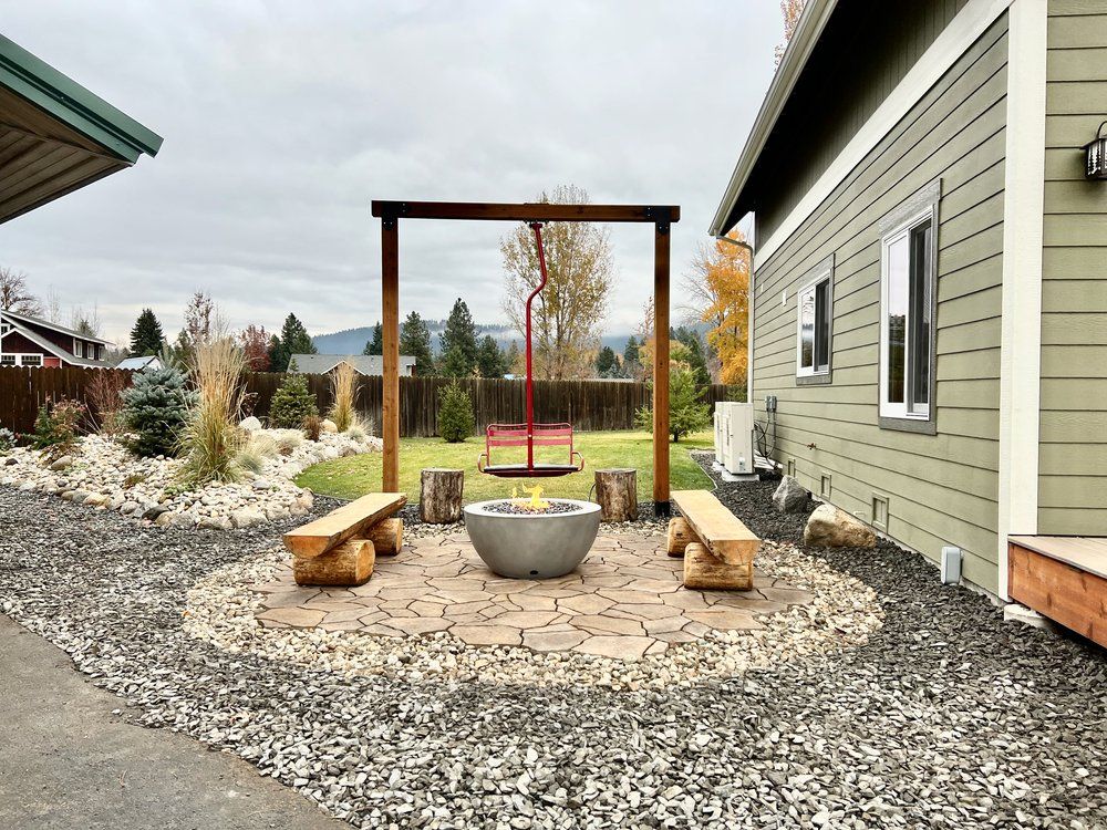 Fire pit between two wooden benches beside the ski lift swing at The Cascade Chalet