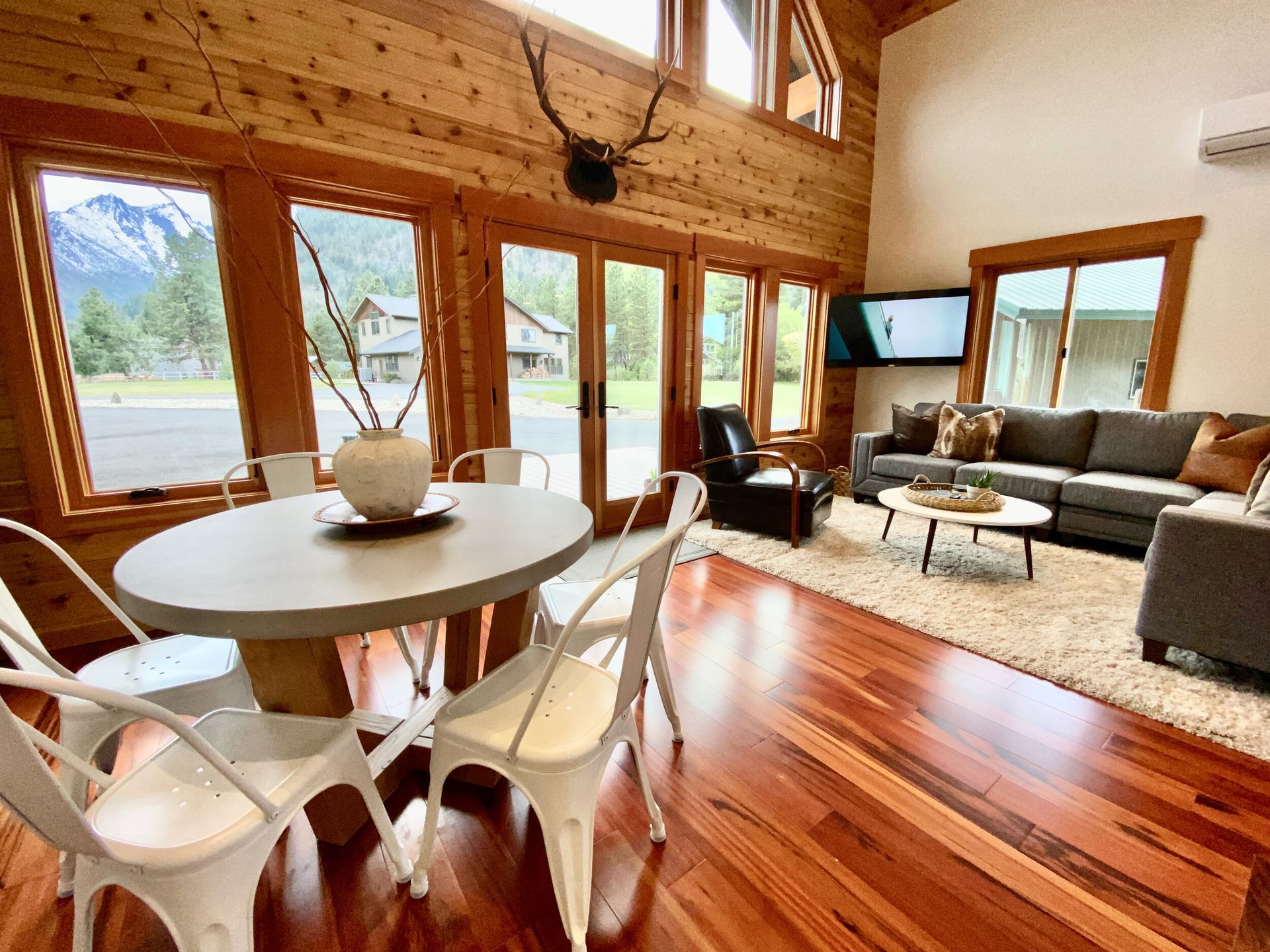 Great room with vaulted cedar ceiling and a wall of windows looking at Wedge Mountain