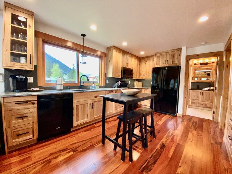 Fully stocked kitchen with custom hickory cabinets, granite counters and an island at The Cascade Chalet