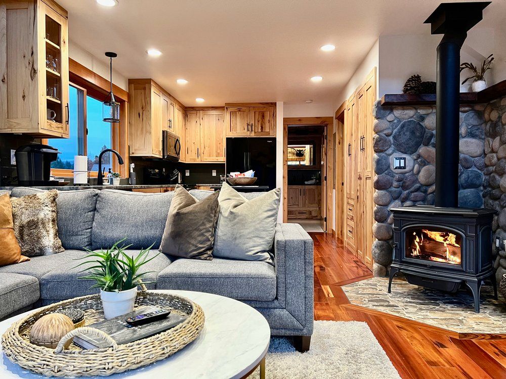 Living room with sectional sofa and a lit wood stove